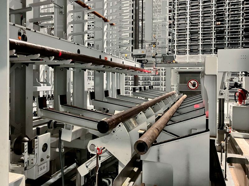 Insgesamt sieben Ausgabestationen vereinzeln die stählernen Stangen bei SEW-Eurodrives und übergeben diese an die Zufuhr-Rollenbahn der Sägen. Im Zentrum des Geschehens agiert ein Wabenlagersystem von Kasto mit 5.140 Plätzen für die Halbzeuge. Es kann drei Tonnen tragen. (Bild: Kasto)