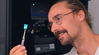 Marius Schöttle M.Sc. ist der Erstautor einer Studie über künstliche Opale als neuartige Sensoren, mit denen sich Temperatur und Zeit messen lassen. Hier sieht man den Bayreuther Forscher mit einem der künstlichen Kolloidkristalle. (UBT / LS Physikalische Chemie I)