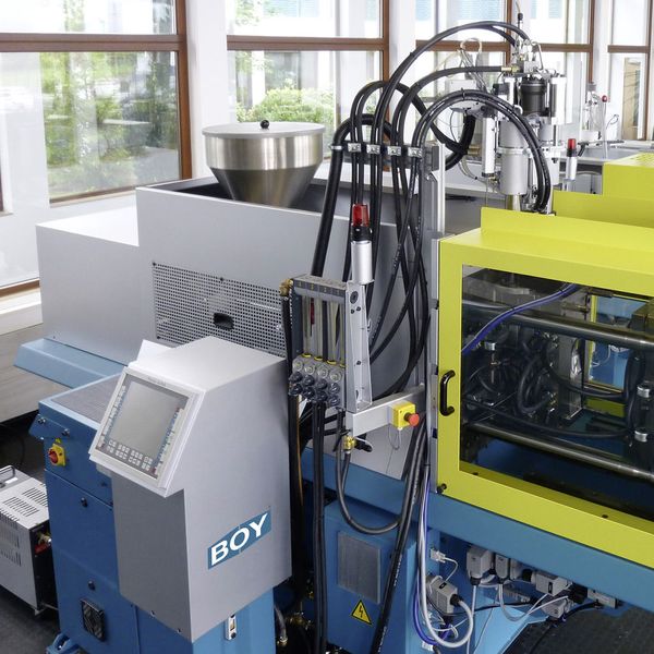 Eine 90 E mit 900 kN Schließkraft produziert in Kombination mit einem Spritzaggregat für die zweite Komponente auf der NPE Sicherheitsbrillen aus zwei verschiedenen Kunststoffen in einem Arbeitsgang.  (Bild: Dr. Boy)