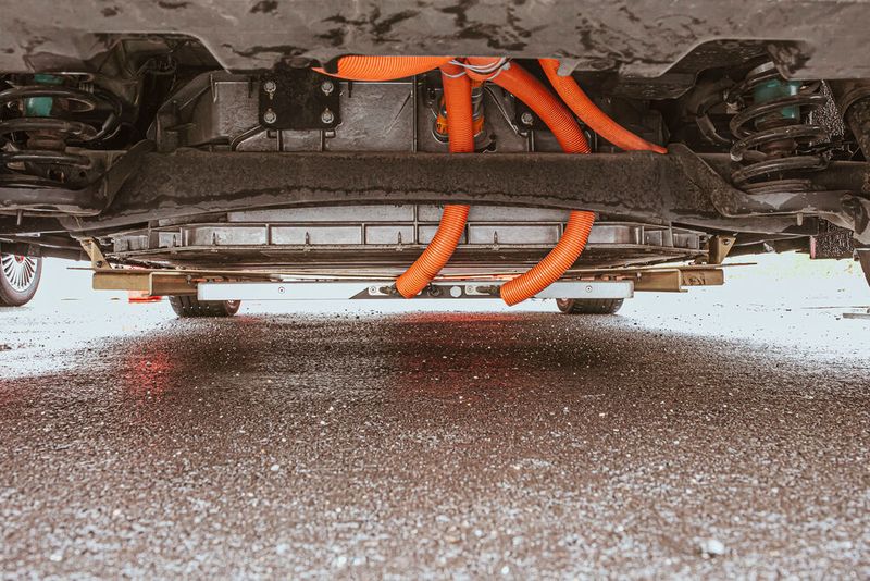 Fast wie bei der Carrera-Bahn: Die Stromabnehmer sitzen am Unterboden der Testfahrzeuge.  (Bild: Stellantis Germany)