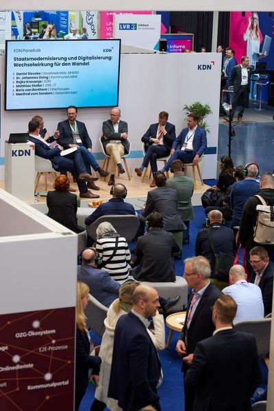 Am ersten Veranstaltungstag fand ein Paneltalk auf der KDN-Bühne in der Messehalle statt. Das Thema: „Staatsmodernisierung und Digitalisierung: Wechselwirkung für den Wandel“ – mit Daniel Sieveke, Staatssekretär im Ministerium für Heimat, Kommunales, Bau und Digitalisierung in Nordrhein-Westfalen und weiteren Diskussionsteilnehmern wie dem Beigeordneten des Städte- und Gemeindebunds Kommunen.NRW, den CIOs von Gelsenkirchen und Oberhausen (NRW) sowie dem Sprecher der Geschäftsleitung von OWL-IT.  (Bild: © Manfred Pollert und DATABUND e.V.)