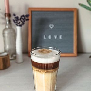  Platz 3: Sanfter Genuss – Der Latte Macchiato  Wer seinen Kaffee noch milder mag, greift zum Latte Macchiato. Laut der Befragungen bevorzugen 31% der Teilnehmer dieses Getränk. Der Latte Macchiato, ebenfalls italienischen Ursprungs, besteht aus viel heißer Milch und einem kleinen Schuss Espresso, was ihm eine charakteristische „befleckte “ Optik verleiht, von der sich der Name ableitet. Diese Schichtung wird oft in hohen Gläsern präsentiert, anstatt in Tassen, um die Ästhetik zu betonen. (Bild:  frei lizenziert/ Kenny Kennethh / Unsplash)