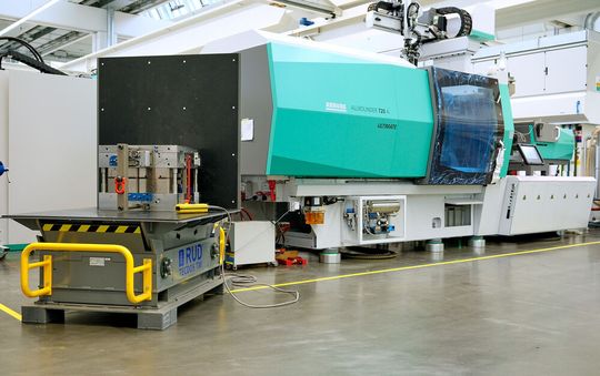 Arburg ist bekannt für seine Expertise beim Bau von Spritzgießmaschinen. Im Kundencenter in Loßburg werden auch Werkzeuge getestet, die bis zu 10 Tonnen wiegen. Ihre sichere und ergonomische Handhabung gelingt jetzt fixer mit dem Wendetisch RUD Tecdos TM (links vorne).(Bild:  RUD / Jensen)