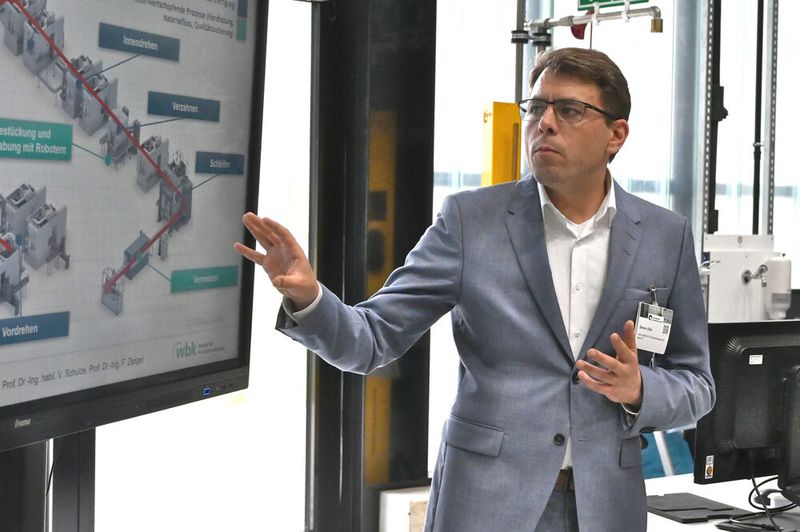 Simon Otto vom Institut für Produktionstechnik am KIT stellte während der Führung das  Forschungsprojekt Wertstromkinematik vor. (Bild: Stefanie Michel)