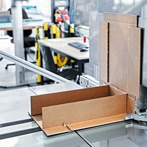 Abhängig von den Dimensionen des Inhalts wird die Wellpappe passend zugeschnitten, perforiert und gerillt; anschliessend kann die Verpackung aufgerichtet, verleimt und zur Einlegestation transportiert werden.