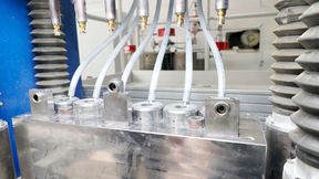Die Presse ermöglicht in dieser Konfiguration, sechs Grünlinge auf einmal zu fertigen. Das Keramikpulver wird automatisch über Rohre zugeführt. Von Hydraulikzylindern angetriebene Auswerfer werfen die fertigen Grünlinge nach oben aus, wo sie ein Robotersystem entnimmt.   (Bild: Maschinenmarkt/rw)