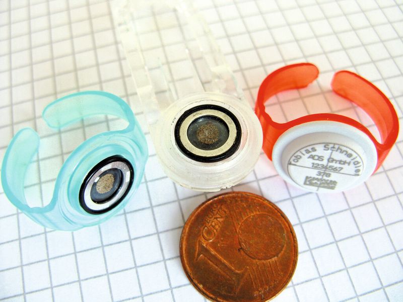 Zwei Fingerringe sowie ein Kopfclip mit eingesetzten Dosimeterelementen. Der rechte Ring ist bereits mit einem Deckel versehen. (Bild: Klaus Vollrath)