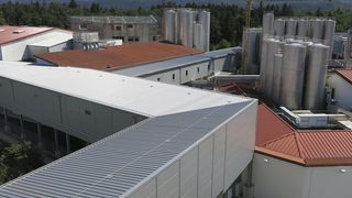 Eine Fördertechnikbrücke verbindet das Hochregallager der Berchtesgadener Milchwerke mit der Produktion und mit zwei bestehenden Lagern. (Bild: Hörmann Logistik)