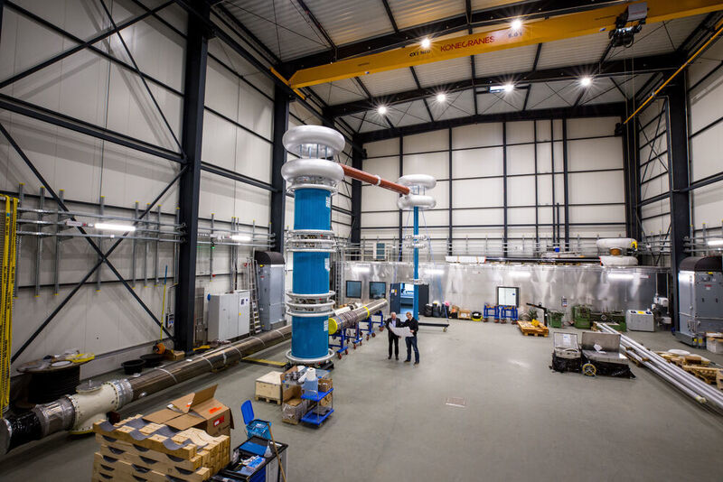 The interior of the new 500 kV DC high voltage hall during the construction phase. The left blue column is the 1.2 MV DC generator. (Gregor Rynkowski / TU Darmstadt)