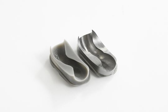 Auf dem 3D-Drucker hergestellte Einzelumlenkung (links) und das nach Modifizierung und Freigabe aus Stahl gefertigte Teil (rechts). Charakteristisch für die Einzelumlenkung sind die komplexen Kurven und Konturen, welche berechnet, konstruiert und gefertigt werden müssen. (Bild:  Joshua Rzepka für Kammerer)