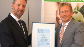 Kai Pilinski, Qualitätsmanager bei Rajapack, erhält die Urkunde zur ISO 14001-Zertifizierung von TÜV-Cert-Seniorauditor Franz Rebstock (im Bild rechts). (Bild: Rajapack)