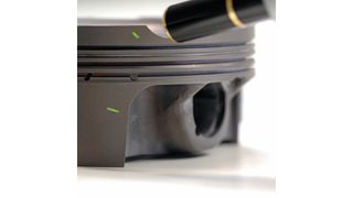 Chemisch abgeschiedene Nickelschicht mit PTFE-Markern auf einem Aluminiumkolben. (Bild: STI)