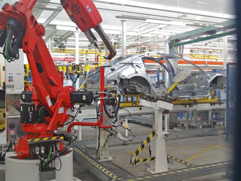 Der Roboter des Typs Smart NJ2 von Comau, ein Schweißroboter, befestigt Karosserieteile. Die meisten Roboter in der Blechbearbeitungsstrecke sind Gelenkroboter. (Bild:)