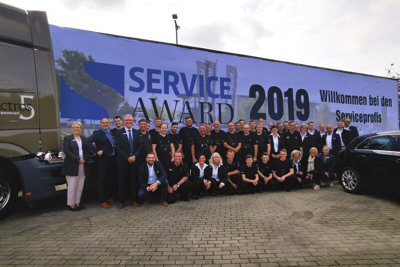 Die eigens für die Jury des Service Awards angefertigte Begrüßungsplane will das siegreiche Team aus Detmold in seiner Werkstatt aufhängen. (Ottmar Holz/»kfz-betrieb«)