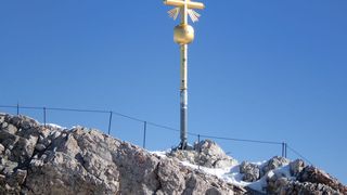 Das Wahrzeichen von Deutschlands höchstem Berg ist sein goldenes Gipfelkreuz. Knapp 400 Meter unterhalb des Gipfels befindet sich das Zugspitzplatt, zu dem die Zahnradbahn fährt. (Bild: Ormazabal)