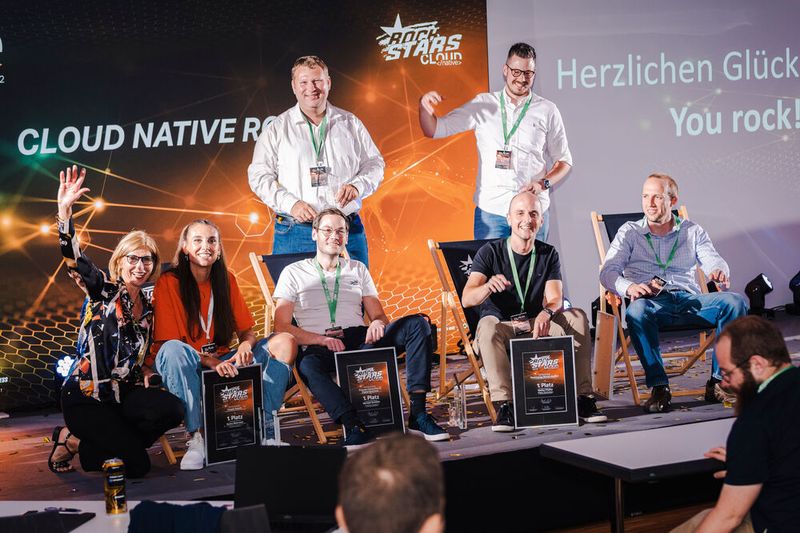 Fabian Früchtenicht (Schmitz Cargobull / NeoGeo New Media GmbH) und Alex Pöllmann (Viessmann, oben, v.l). freuen sich mit den hier sitzenden Rockstars, denn Daniela Schilling, Leiterin der Vogel IT-Akademie (u.l.), hatte sich etwas Besonderes für Emma Wehrwein (eco – Verband der Internetwirtschaft), Sebastian Langer (in Vertretung für Michael Schöller, Schmitz Cargobull), Stefan Pfaffel (Allianz Technology) und Benny Woletz (Cloudwürdig) ausgedacht. Weitere Bilder im Rückblick der Vogel-IT-Akademie. (Bild: berndrottmann.com)