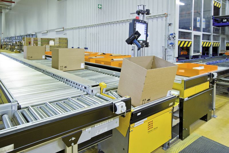 Sowohl die Behälter mit der zu kommissionierenden Ware (rechts) als auch die Leerkartons (links) werden optimal positioniert. Dafür sorgen jeweils eine Hub- und eine Kippstation an jedem Kommissionierarbeitsplatz. (Bild: F&K)