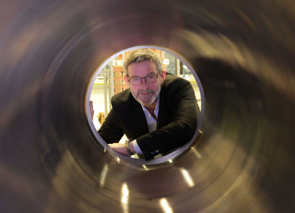 Der Leiter des Siemens Subsea Technology Centers Jan Erik Lystad blickt durch einen Hochdruckbehälter. Darin werden Komponenten des 