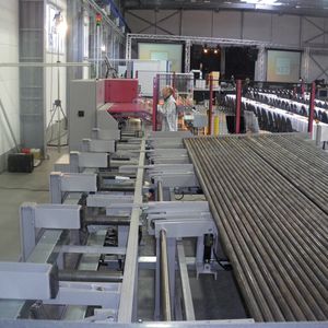 Vor dem Sägen wird die aufgelegte Stange vermessen. Eine CNC-Nachschubzange regelt die Zufuhr in die Kreissäge.