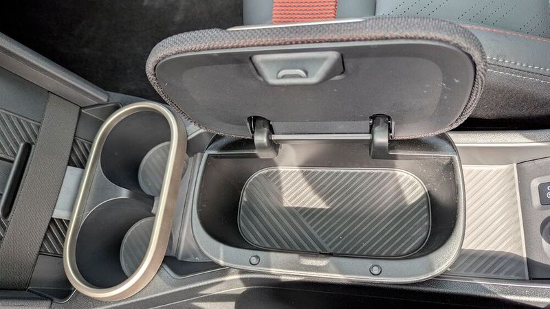 Zwei Cupholder und eine kleine Schachtel mit Deckel dienen als Ablage; das Handy kann aufrecht stehend induktiv geladen werden. (Bild: Rosenow – VCG)