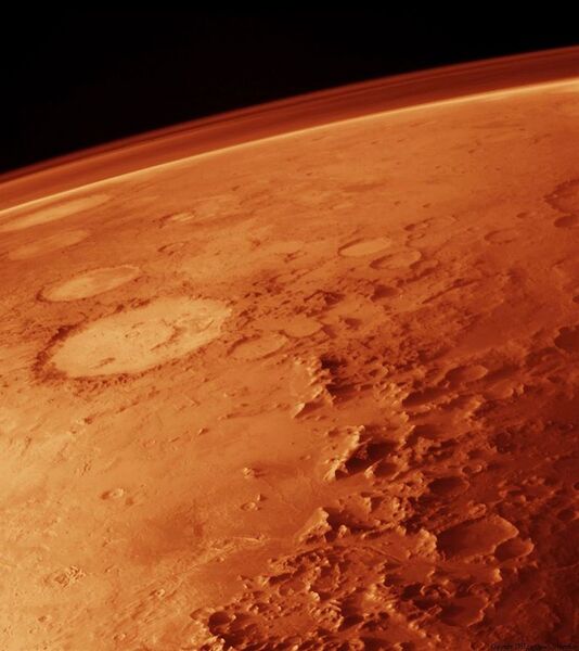Sur cette image on voit parfaitement l’atmosphère de la planète le long de sa courbure à l’horizon. La pression atmosphérique moyenne est de 600 Pa (0,6 kPa, soit 6 millibars, environ 170 fois moins que sur Terre) et sa masse totale est de 25 tératonnes. L'atmosphère de Mars est en majorité composée de dioxyde de carbone (95 %), de diazote (3 %) et d'argon (1,6 %), et contient des traces de dioxygène, d'eau, et de méthane. Elle est poussiéreuse pendant les tempêtes, conférant au ciel une couleur rouille lorsqu'elle est observée depuis la surface, et bleue lors des périodes d'accalmies. (Image: Nasa)