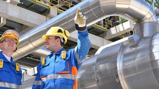 Zwei Mitarbeiter bei einem Rundgang durch eine Raffinerie. (Bild: industrieblick - stock.adobe.com)
