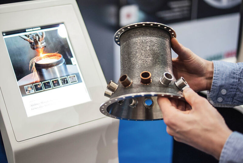 Per Laser gesintertes Hochleistungsbauteil aus einer herkömmlich nur schwer zu bearbeitenden Metalllegierung, fix und fertig mit Anschlusskomponenten und Lochkränzen zur Montage. (Messe Stuttgart)