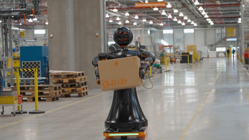 Effizienter Materialfluss: Der humanoide Roboter Iggy Rob nutzt seine autonome AMR-Basis, um Pakete sicher durch Produktions- und Serviceumgebungen zu transportieren.(Bild:  Igus SE & Co. KG)