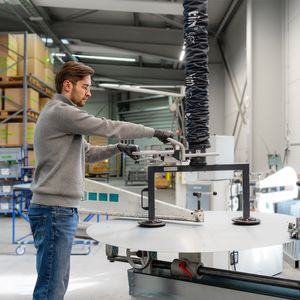 Präzises Einlegen: Mit einer Sondertraverse und dem Lightlift 30 kg werden großformatige Blechscheiben kontrolliert in den Kreisschneider eingebracht.  (Bild: Timmer GmbH)