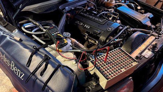 Vor OBD-Ära: Bei der Fehlersuche an einem Mercedes-Benz 190 E 2.3-16 wird mit Buchsenkasten („Brake-out-box“) und klassischer Messtechnik gearbeitet.(Bild:  AGVS-Medien)