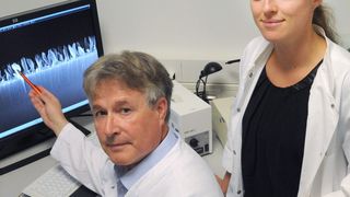 Prof. Dr. Manfred Köller und Dr. Christina Sengstock zeigen die mikroskopisch vergrößerte Seitenansicht der nanostrukturierten Titanoberfläche. (Bild: V. Daum / Bergmannsheil)