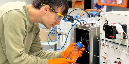 Battist Utinger untersucht im Labor das oxidative Potenzial von Feinstaubpartikeln. Mit einem an der Universität Basel entwickelten Messgerät lässt sich bestimmen, wie stark die Partikel schädliche oxidative Reaktionen auslösen können.(Bild:  Christine Müller, Swiss Nanoscience Institute, Universität Basel)