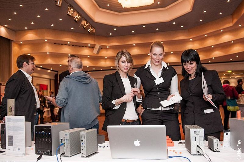 Aurélie Rigollier, Account Manager bei Lacie sowie Claudia Meyer-Venecia und Claudia von Bihl von der Firma Comspot, begutachtendie Design-Produkte von Lacie. (CPN IT-Verbundgruppe)
