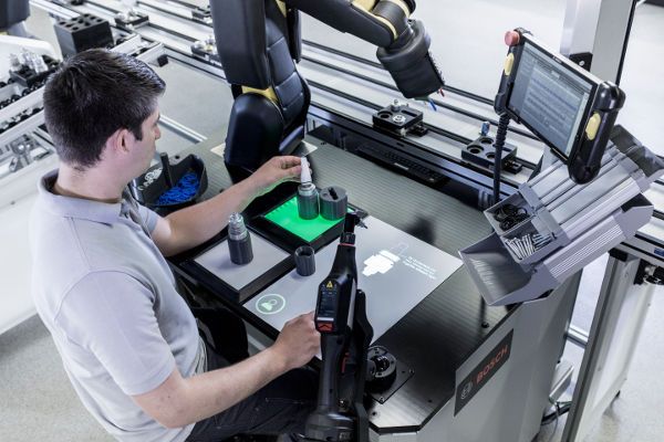 Demonstration der vernetzten Arbeitsplatzlösungen von Bosch auf der Hannover-Messe 2017. Fertigungsroboter und Menschen sollen als Kollegen am Arbeitsplatz fungieren. Der Arbeitsplatz der Zukunft passt sich dem Mitarbeiter an. (Bild: Bosch)