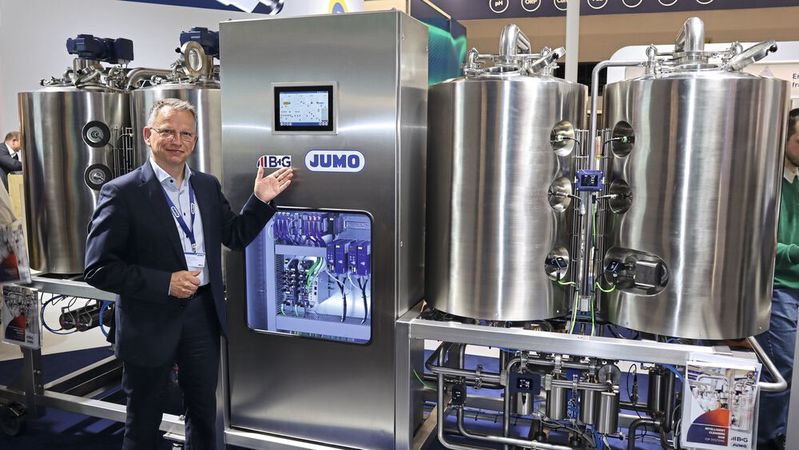 Christoph Trott, Head of Strategic Product Management bei Jumo, vor der Mini-Brauerei: „Mit unseren vorgefertigten Systemen machen wir es dem Anwender leicht.“ (Bild:  PROCESS / Kempf)