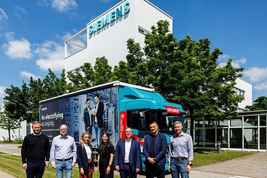 Gruppenbild zur „Begrüßung“ des E-Trucks von Gruber Logistics im Leipziger Werk von Siemens Smart Infrastructure.(Bild:  Siemens/Jens Schlüter)
