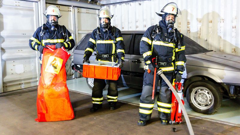 Bringen sich während der Übung in Stellung, um ein E-Auto zu löschen: ein Löschtrupp inklusive Recover-E-Bag und Wagenheber. (Bild: Samoiski)