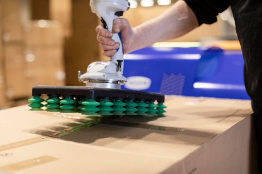 So sieht es jetzt aus, wenn im Homberger Lager des dänischen Möbelherstellers JYSK schwere Pakete gehandelt werden. Dieser Multigreifer von Schmalz in Kombination mit dem relativ neuen Vakuumschlauchheber Jumboflex Picker schont nun den Rücken der Lagermitarbeiter. So sieht es jetzt aus, wenn im Homberger Lager des dänischen Möbelherstellers JYSK schwere Pakete gehandelt werden. Dieser Multigreifer von Schmalz in Kombination mit dem relativ neuen Vakuumschlauchheber Jumboflex Picker schont nun den Rücken der Lagermitarbeiter.