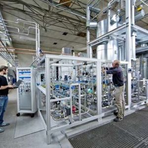 ZSW-Forscher bei der Kontrolle der Gasmischung. Im Hintergrund die Methanisierungsanlage.