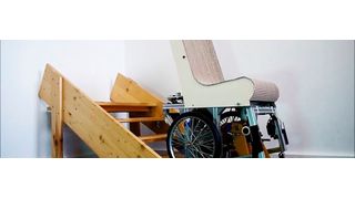 Ein Demonstrator-Modell des Assist Mobil während des Treppensteigens; die Beine befinden sich unterhalb des Rollstuhls und schieben ihn von Stufe zu Stufe. (Steinbeis-Transferzentrum)