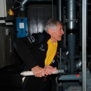 Autarke Energiegewinnung im Atombunker: Der geschäftsführende Gesellschafter Volkmar Schmeltzer demonstriert die Funktionsfähigkeit der Energieanlage und erzeugt durch Kurbeln Strom. (Bild:  Baeuchle/»kfz-betrieb«)