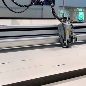 Blick auf den Laserschneidkopf einer 3XL-3200 von Eurolaser, wie er das robuste Polypropylen-Mischgewebe automatisch in Form bringt. Vorbei sind die Zeiten, in denen Mitarbeiter mühsam per Heißschere arbeiten mussten.(Bild:  Eurolaser)