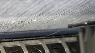 Einbringen der elektrisch leitfähigen Fäden in den Maschenbildungsprozess. (Foto: TU Dresden/ITM)