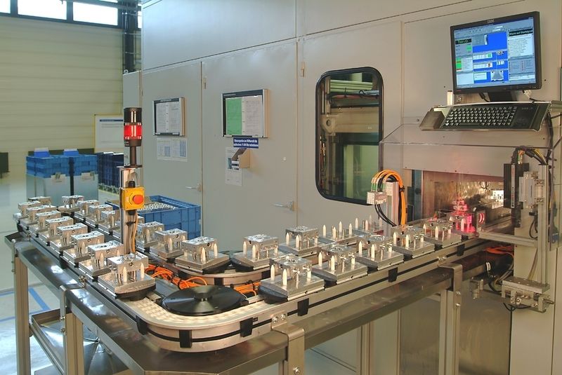 Abb.3: Einsichten: Im Zuführbereich werden die aus der spanenden Fertigung kommenden Pumpengehäuse manuell auf Werkstückträger aufgelegt und auf dem VarioFlow Kettenfördersystem lagerichtig der Entgratmaschine zugeführt. (Archiv: Vogel Business Media)