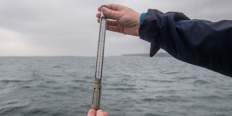 Karen Helen Wiltshire hält ein Termometer. An der „Helgoländer Straße“ läuft seit 1962 täglich die detaillierteste Langzeitüberwachung des Meeres. Seit fast 60 Jahren kämpft sich jeden Tag ein kleines Forschungsschiff aus dem Hafen auf Helgoland in die offene Nordsee. In den vergangenen 60 Jahren betrug die durchschnittliche Erwärmung des Wassers an der Helgoländer Straße 1,9°C, was etwa dem Doppelten der Erwärmung des globalen Ozeans entspricht.(Bild:  Alfred-Wegener-Institut / Esther Horvath)