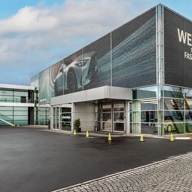 Im Eingangsbereich von Mercedes-AMG wird man bei der „weltweit schnellsten Familie“ willkommen geheißen. (Bild: faktorzwei GmbH)