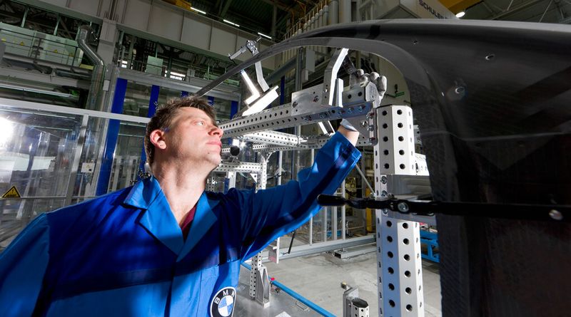 Ein BMW-Mitarbeiter prüft an einer Messaufnahme die Qualität eines gefertigten CFK-Seitenrahmens. (Bild: BMW)