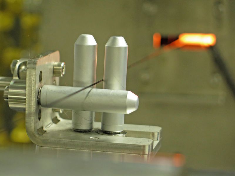 Letzter Akt in Richtung Hightechfaser: Über eine metallene Fadenführung werden die Präkursorfasern in den Carbonisierungsofen gefördert. (ITCF)