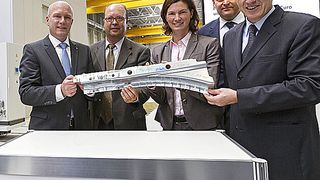 Presswerksmitarbeiter Stefan Berger,  Oberbürgermeister Joachim Wolbergs, BMW Betriebsratsvorsitzender Werner Zierer,  Landrätin Tanja Schweiger, BMW Technologieleiter Dr. Robert Engelhorn und Werkleiter Dr. Andreas Wendt mit dem ersten Bauteil – einem Längsträger – der neuen Presse GP 661. (Bild: BMW / Florian Hammerich)