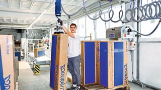 Fertig für das Einlagern: Mit dem Vakuum-Schlauchheber JumboFlex werden selbst unhandliche Kartons im Format von 50 cm x 150 cm von der Rollenbahn auf die Palette transportiert. (Schmalz)